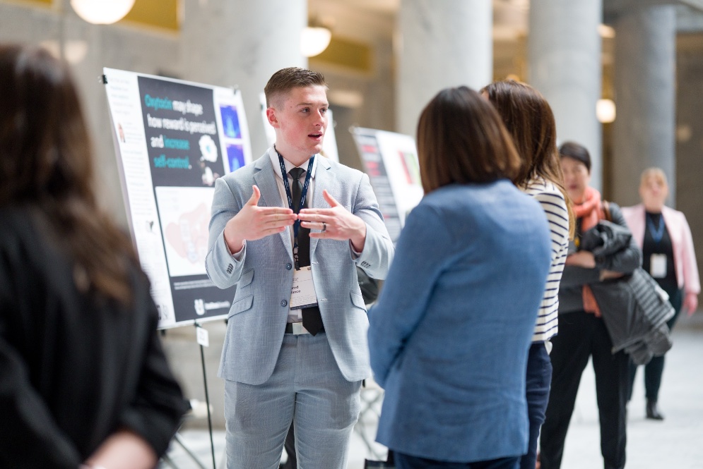 student in gray suit presenting