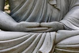 Statue with hands together on lap