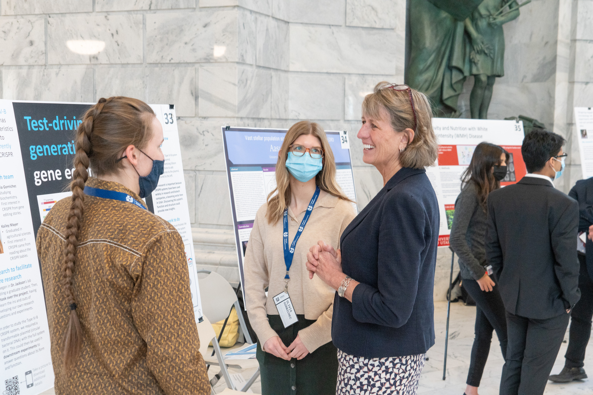 President Noelle Cockett meeting with student presenters Kailey Welch and Olivia Gornichec in the Rotunda of the State Capitol during the 2022 Utah Research on Capitol Hill