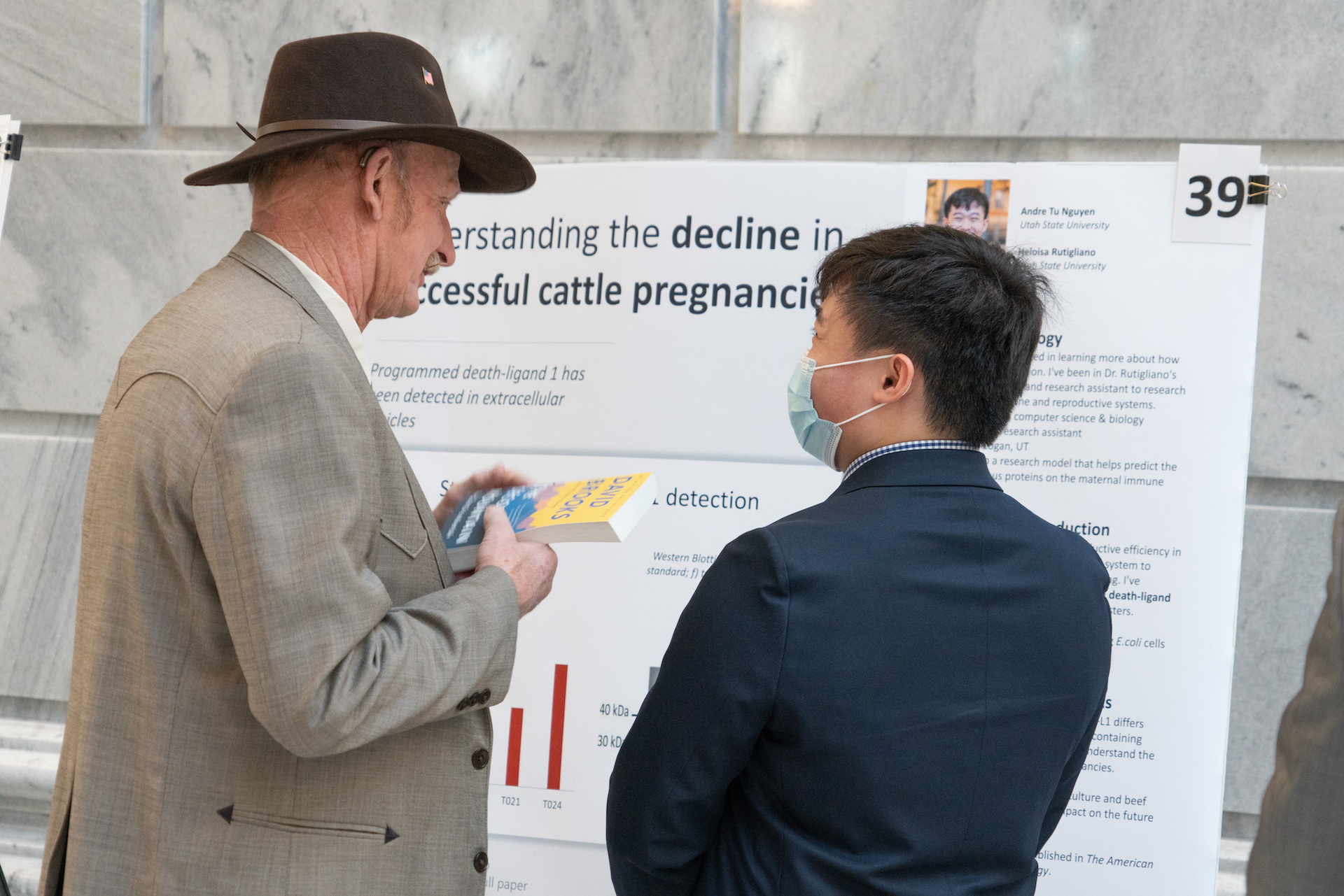 Biology student Andre Nguyen shares his work with Representative Scott H. Chew  in the Rotunda of the State Capitol during the 2022 Utah Research on Capitol Hill